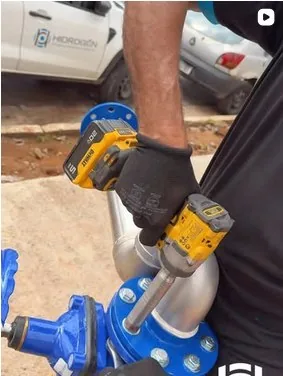 Publicação: aperto do flange com parafusadeira em campo, com a van da Hidrogên ao fundo.